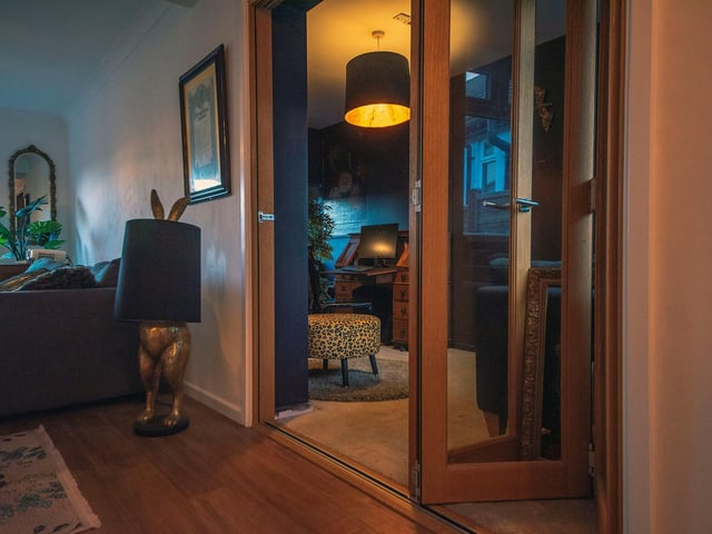 From the hall is the open plan living space, which has been portioned into three distinct areas that stretch the way of the entire house. The warm and cosy living room lies to the rear of the property.