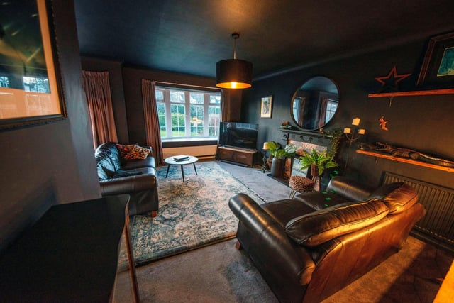 This room is currently being used as an additional lounge area. The current owners have decorated it in dark, moody, warm hues with plenty of added textiles and warm lighting.