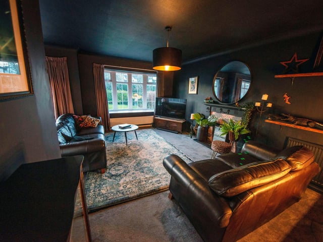 This room is currently being used as an additional lounge area. The current owners have decorated it in dark, moody, warm hues with plenty of added textiles and warm lighting.