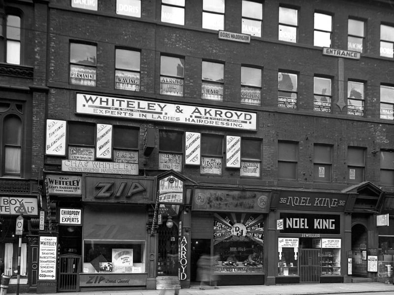 Shops on Boar Lane in February 1944. They include Noel King, jewellers, a shoe repair shop, Zip french cleaners and Black Boy Chocolate Co. Ltd. Above is Whiteley & Akroyd, ladies hairdressers and Doris Waddington's dancing school.