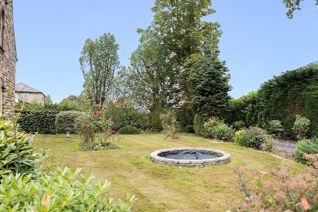 This is an established garden with trees and shrubs, along with a central pond.