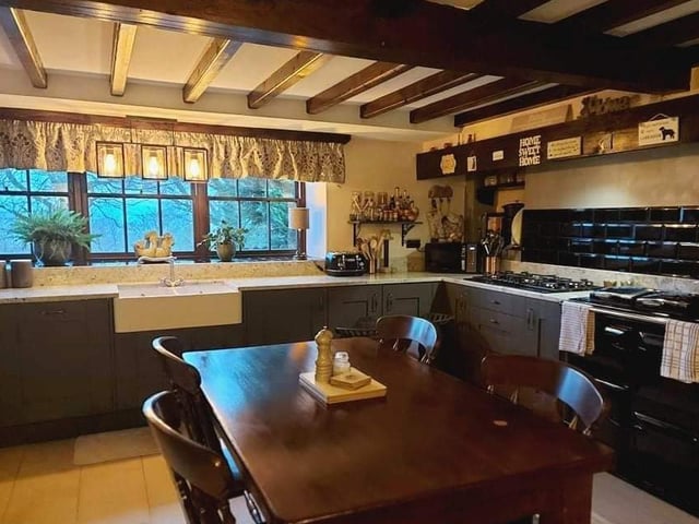 The dining kitchen has fitted base units, an inset sink, an oil-fired 'Rayburn' stove, an integrated electric oven with tiled splash back, and a range of built-in appliances.