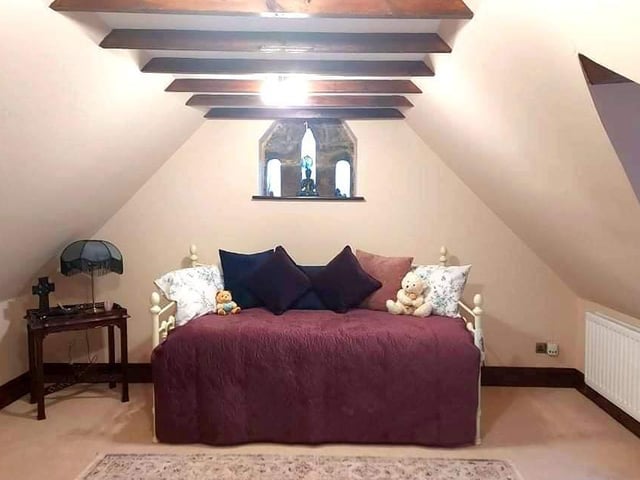 Beams and a window feature add to the charm of this room within the conversion.