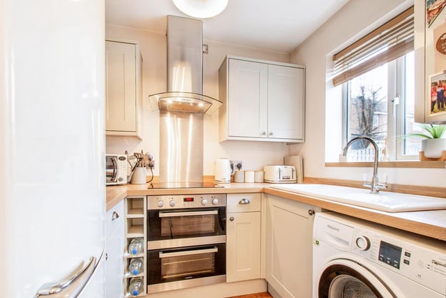The kitchen is a modern 'shaker style' with a range of wall and base units, ceramic sink and drainer, electric hob and double oven, cooker hood, plumbing for washing machine and window to the rear.