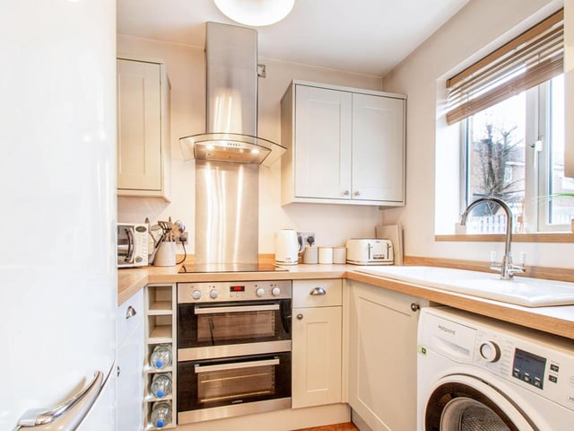 The kitchen is a modern 'shaker style' with a range of wall and base units, ceramic sink and drainer, electric hob and double oven, cooker hood, plumbing for washing machine and window to the rear.
