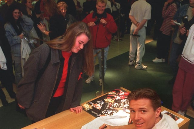 Athlete Roger Black signs autographs for fans during a visit to  Lilywhites at The Headrow Centre in December 1996.
