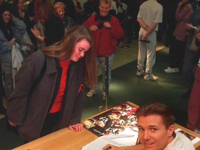 Athlete Roger Black signs autographs for fans during a visit to  Lilywhites at The Headrow Centre in December 1996.
