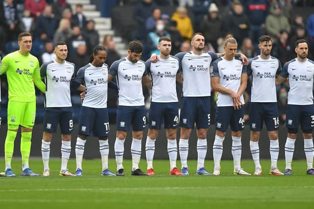 Preston North End players observe a minute's silence in memory of the PNE fans who passed away in 2021