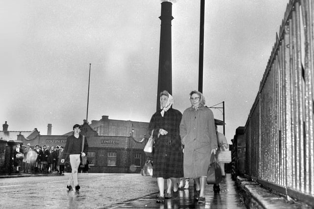 Workers at the end of a rainy day leaving Eckersleys Mill, Swan Meadow Road, Wigan, along Pottery Road, in 1967. The cotton mill finally closed down in the early 1970s.