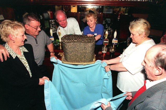 A pile of 10 pence pieces and £1 coins raised for Wheatfields Hospice are demolished at The Three Horse Shoes in Headingley in May 1999. Pictured, from left, are publicans Lesley and Trevor Hodgson, regular Michael McMillan Beverley Dickinson from Wheatfields, Irene Moran from Wheatfields and oldest regular Jack Clark.