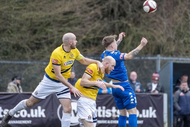 Pontefract Collieries try the aerial route to goal with Nick Guest challenging two Marske United defenders for the ball.  Picture Scott Merrylees.
