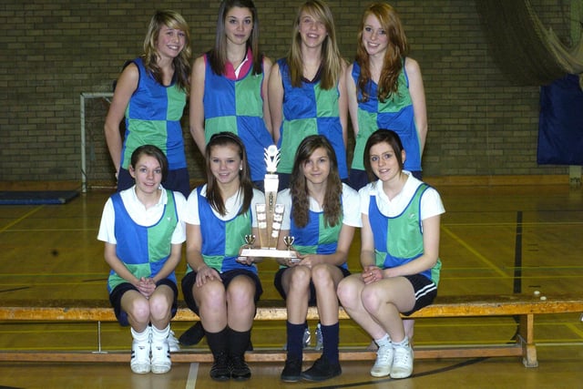 Whitby Community College's girls cross country team champions with their trophy.