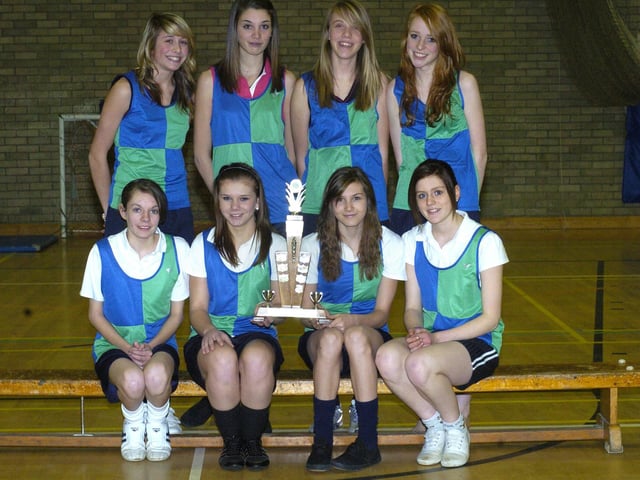Whitby Community College's girls cross country team champions with their trophy.