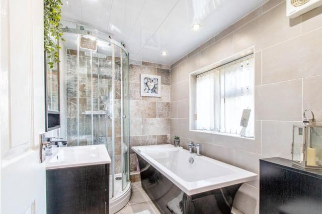 The family bathroom is a modern space with walk in shower and separate bath.