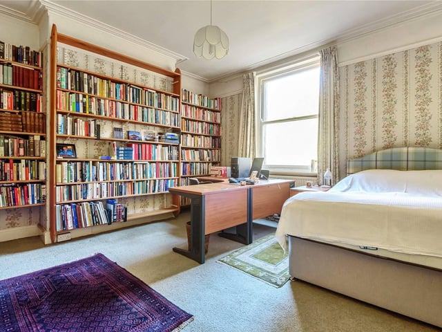 One of the other bedrooms, which currently houses plenty of books and a spare desk space.
