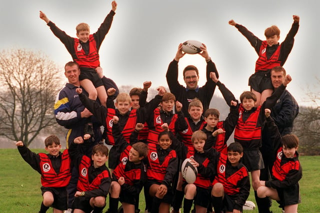 Members of Weetwood Primary School rugby team celebrate after receiving a new rugby kit. They are pictured with, back from left, Leeds RL star Nick Fozzard and PE teacher Kevin King.