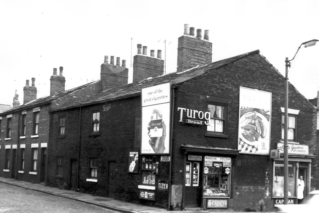 Two shops fronting onto Armley Road in February 1964. Pictured is a small grocers on the corner of Scalby Street, and Leslie Jackson, gent's hairdresser. The man in a white coat standing in the doorway may have been the proprietor. A glimpse of Whitby Street can be seen to the far right.