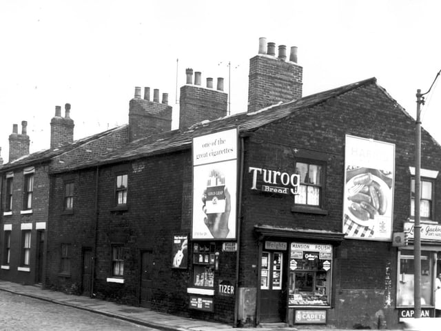 Two shops fronting onto Armley Road in February 1964. Pictured is a small grocers on the corner of Scalby Street, and Leslie Jackson, gent's hairdresser. The man in a white coat standing in the doorway may have been the proprietor. A glimpse of Whitby Street can be seen to the far right.
