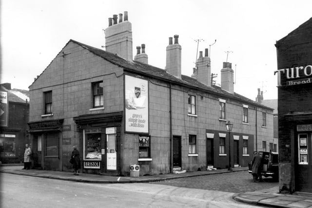 Armley Road with Pickering Street in February 1964. The shop on the left, was part of the business premises of Armely Electronic Company. The adjacent shop is J. Pickles, groceries and sweets, and is on the corner with Scalby Street. On the opposite corner is a small grocers shop.