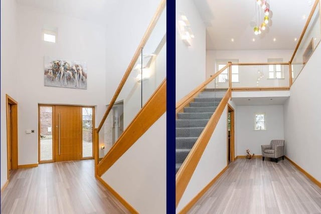 The feature staircase with glass balustrade leads to a gallery landing.