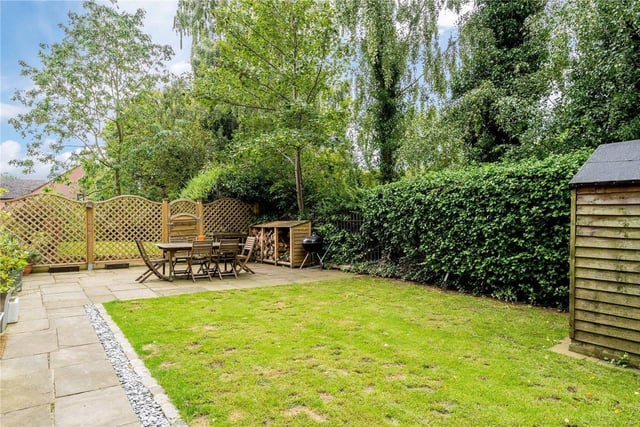 Outside is a small private garden, with a lawned area, shed and a decked area with log storage and a barbecue.