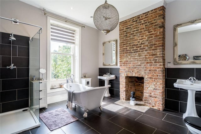 It is accompanied by the family bathroom in which the striking exposed brick fireplace is contrasted with the luxurious black tiles and white suite - including standalone bath.
