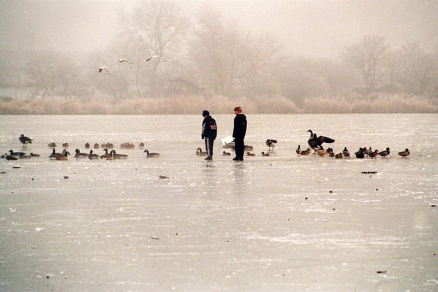 Two young boys walk across the frozen ice on Yeadon Tarn in December 1995.