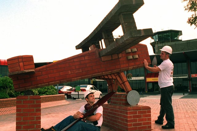 Bricklayers Paul McKay (left) and Damien Laws put the finishing touches to their brick built biplane which is on display outside Leeds Bradford Airport in September 1995.