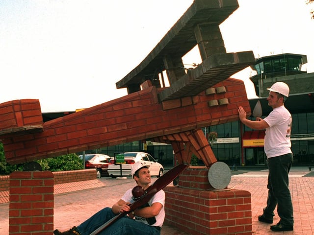 Bricklayers Paul McKay (left) and Damien Laws put the finishing touches to their brick built biplane which is on display outside Leeds Bradford Airport in September 1995.
