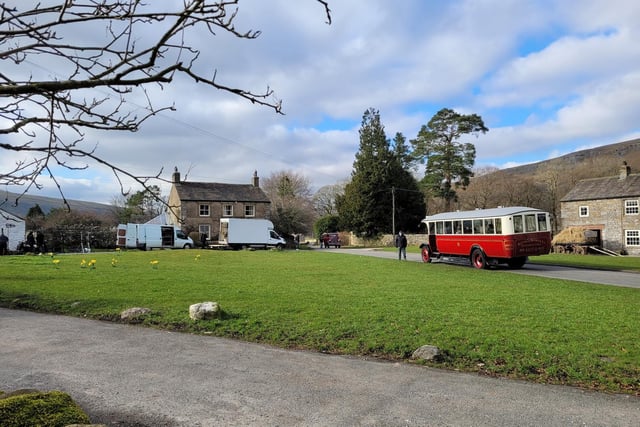 A large red bus was seen reversing down a road in the village