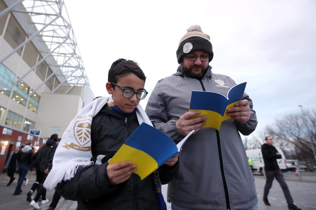 Fans browse the programme ahead of kick off.