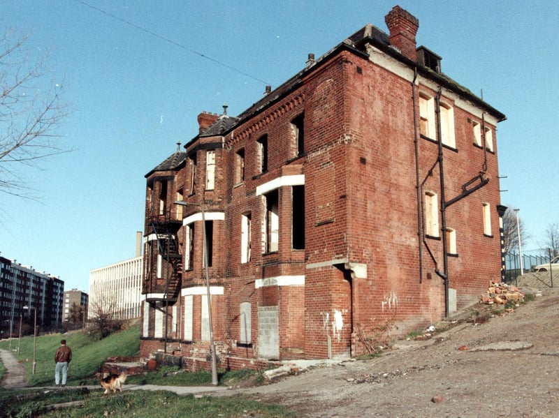 A man and his dog walk across a field near the now-demolished Old Bank Club, which used to stand atop Cavalier Hill. Mount St Mary's High School can be seen in the background.