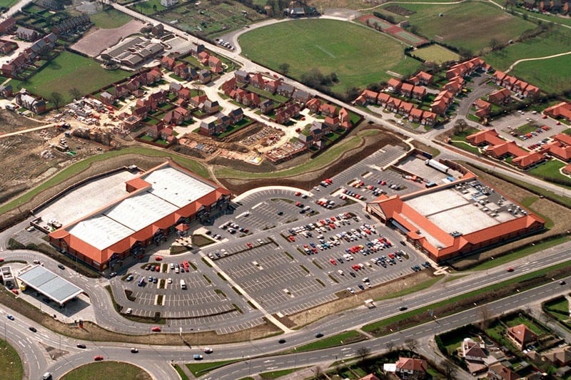 Colton Retail Park alongside the A63 with a block of mixed outlets on left and Sainsbury's on right and the green oasis of Colton Cricket Club at top off School Lane.
