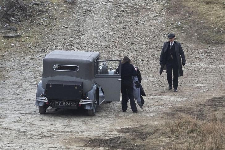 Cilian Murphy can be seen driving up in his vintage car before confronting a group of townsfolk, while appearing to have a gun drawn in his right hand.