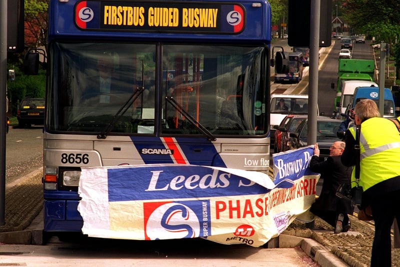 One of the Leeds Guided Buses breaks through the paper banner to open phase 3 on Scott Hall Road.