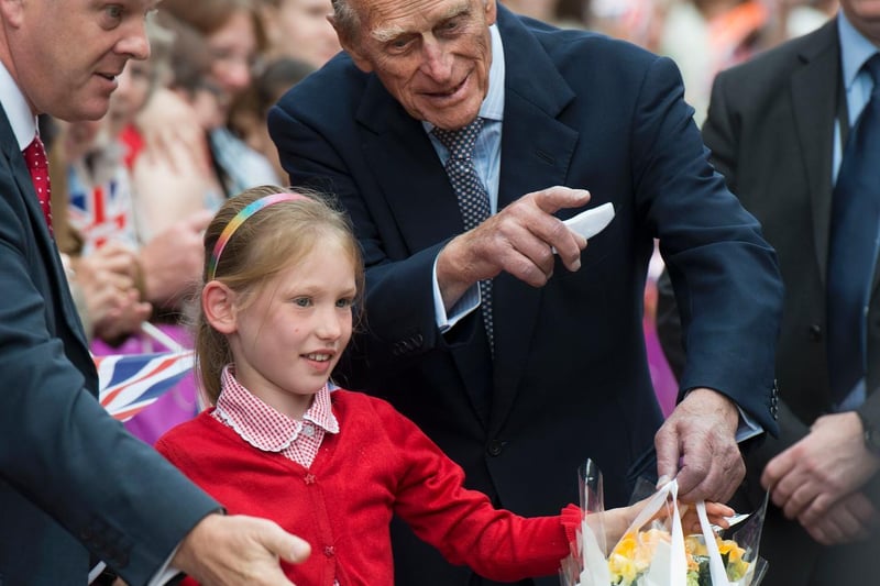 Prince Philip, Duke of Edinburgh, directs a young well-wisher during a visit by the Queen to the City Varieties Music Hall in July 2012.