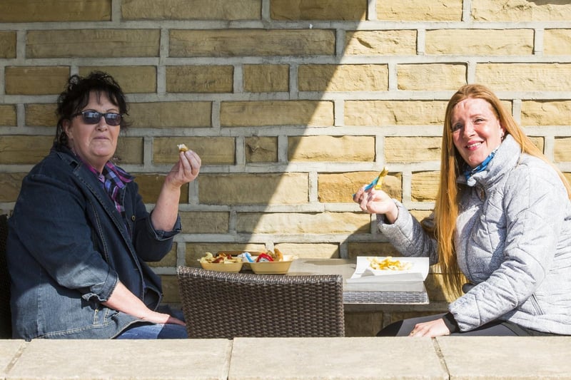 Beverley Groenewald, left, and Sharon Devine enjoy fish and chips outside Blakeley's, Brighouse.