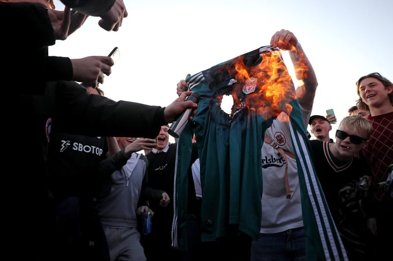 Fans burn a Liverpool replica shirt outside Elland Road against Liverpool's decision to be included amongst the clubs attempting to form a new European Super League.