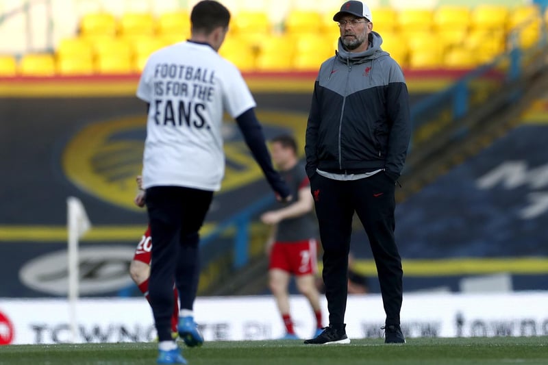 Liverpool manager Jurgen Klopp looks on as a Leeds United player warms up on the pitch wearing a shirt opposing the new European Super League ahead of the match.