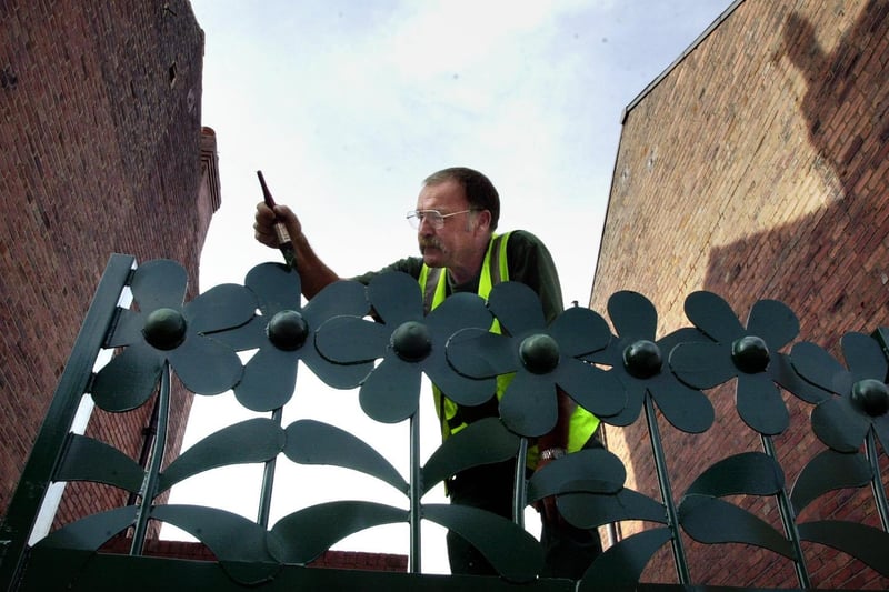 August 2001 and Paul Wilson from Groundwork Leeds works on one of the giant flower metal railings and gates in Garnet Grove.
