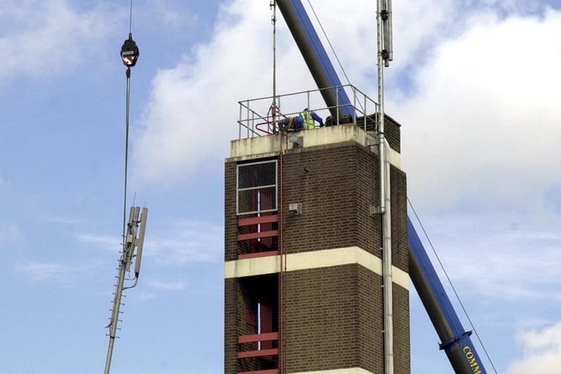Workmen take down the phone mast on the top of Rothwell Fire Station in June 2003.