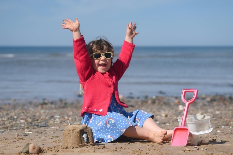 Three year-old Lily Jarvis builds a sand castle on sun soaked beach.