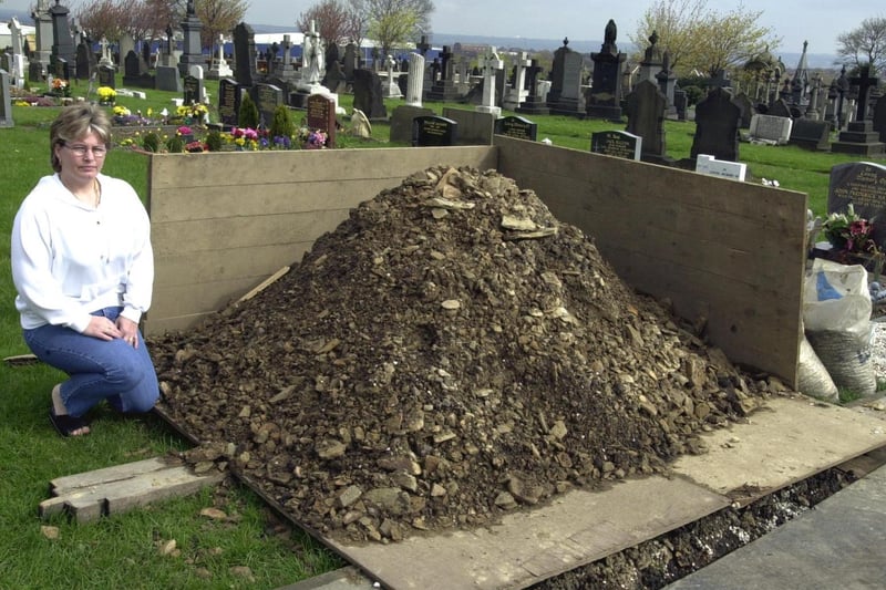 Tina Bullers next to the mountain of earth which has been dumped on her mother's grave at Bruntcliffe Cemetery.