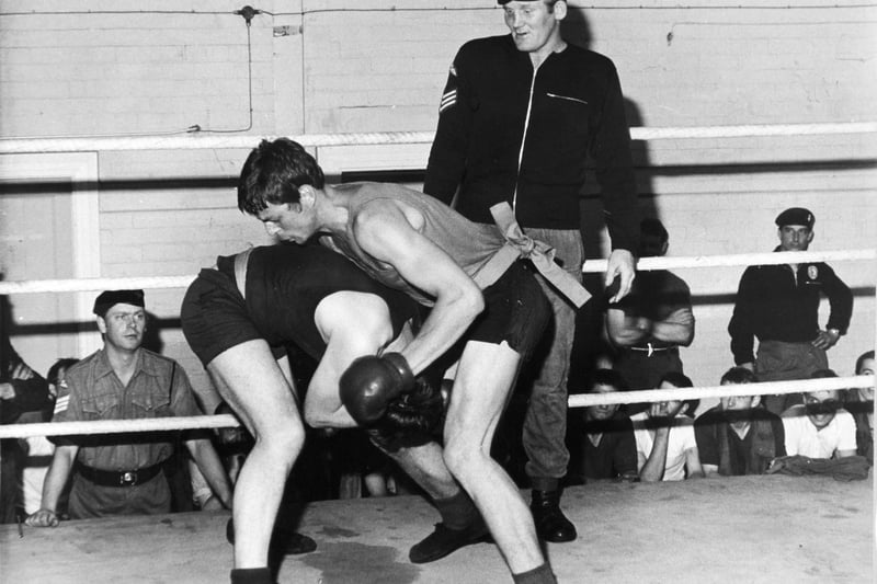 Sergeant Richard Dunn, a parachute regiment contender for the British heavyweight boxing championship, supervises a bout in the ring at Pudsey in July 1973.