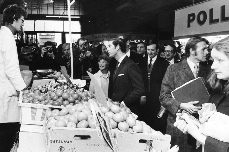 Prince Charles, The Prince of Wales, chats to a greengrocer in Kirkgate Market, Leeds, during his walkabout in December 1975.