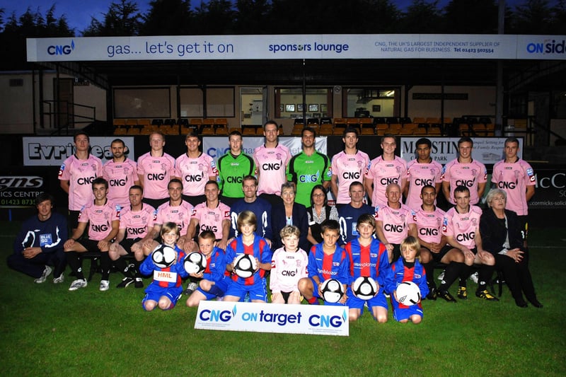 NADV. Harrogate Town first team wear their new pink away strips supporting Breast Cancer. Pictured with the team are Pannal Ash JFC and some of the Macmillan Nurses. 100922AR4pic2.