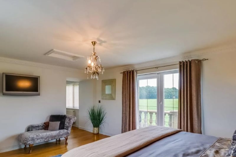 A spacious master bedroom with double glazed patio doors opening onto a balcony, coving to the ceiling, central heating radiator, door through to a dressing area.
