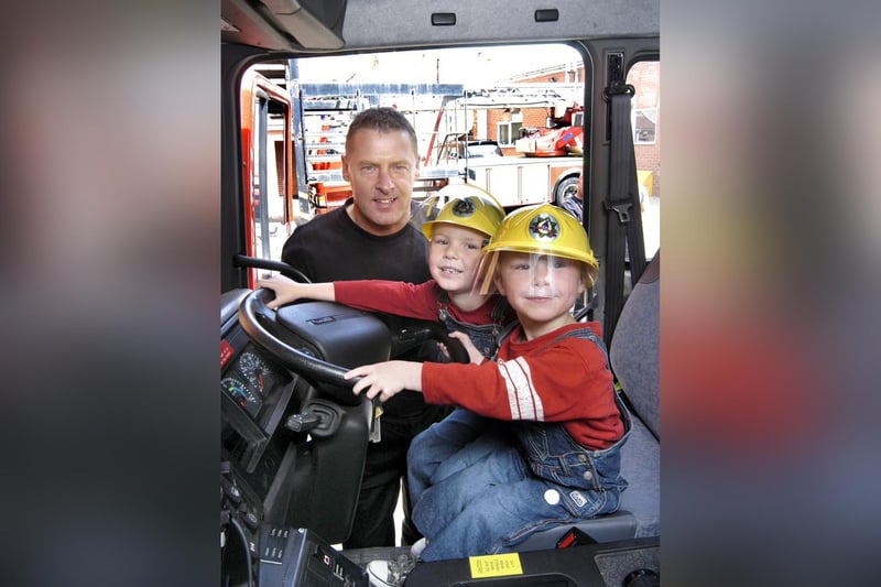 Simon and Alex Whittleton learn about fire engines. Pictured with fireman Dave Fenwick.