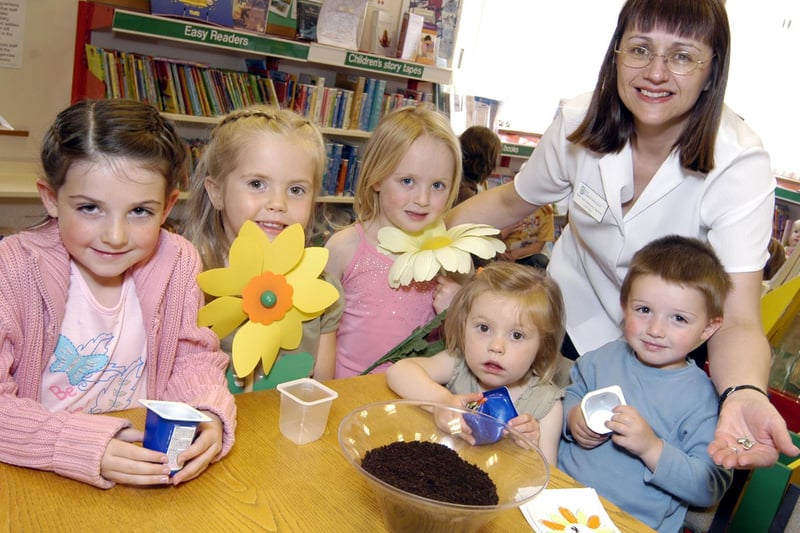 Planting sunflower seeds at Filey Library is Lesley Jenkinson of the library with some of the children.