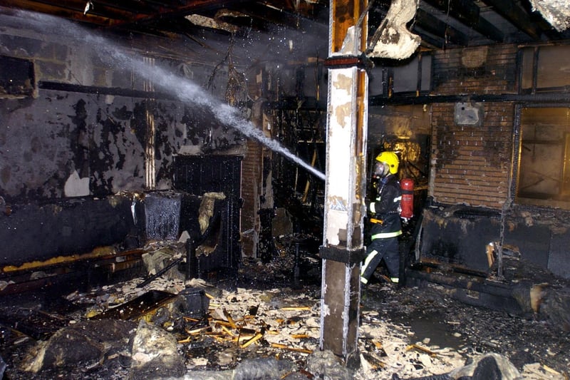 A firefighter damps down the interior of the Compton Arms in Harehills after a blaze took hold in February 2004.